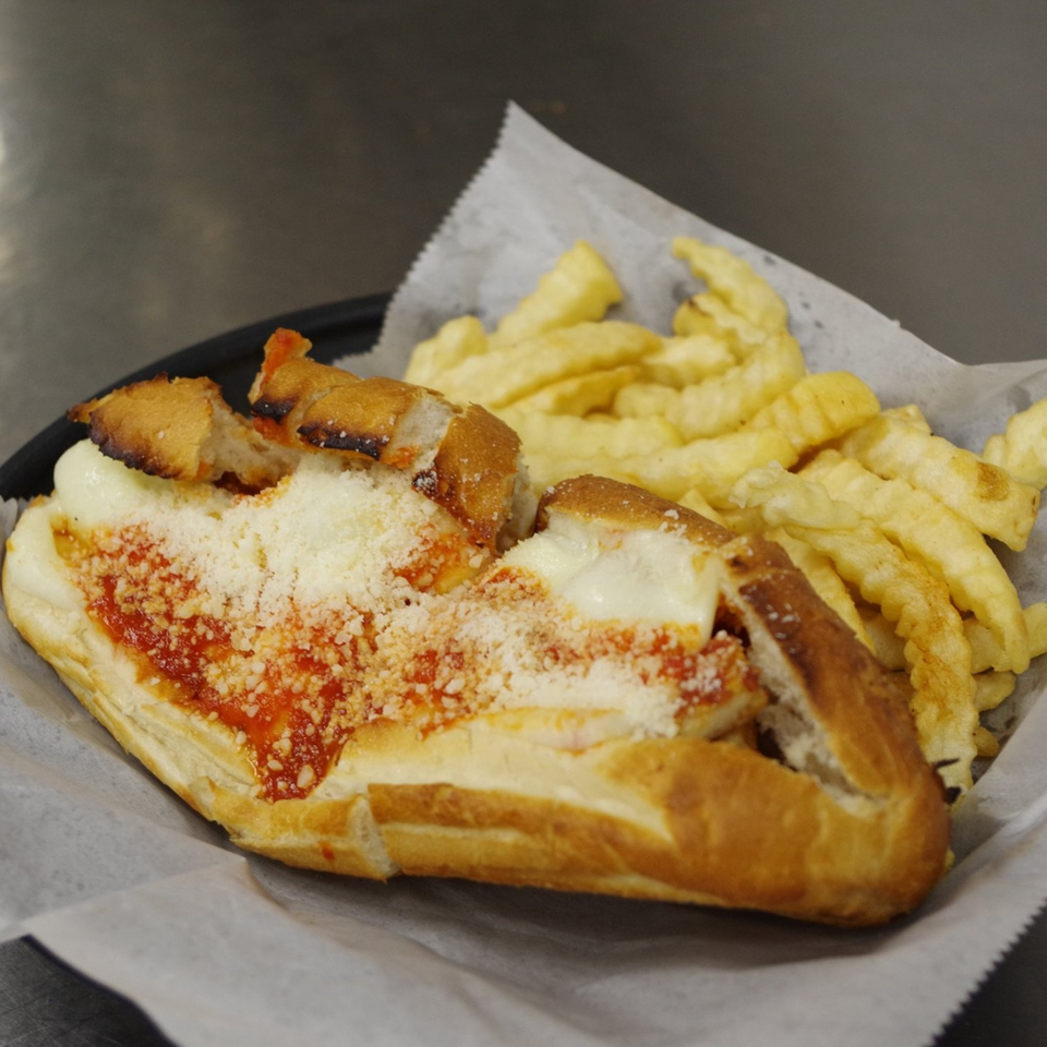 A Coppola's Pizzeria chicken parmesan sub with marinara, melted cheese, and fries.